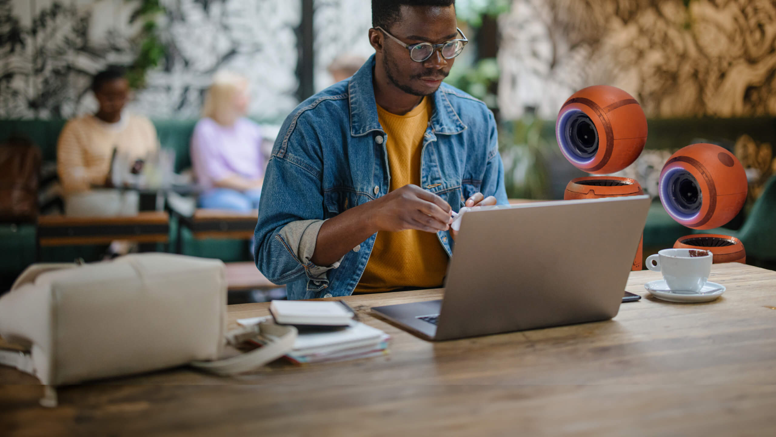 man in cafe on laptop with ii robots