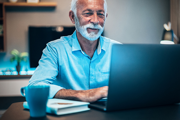 Senior investor using laptop at home