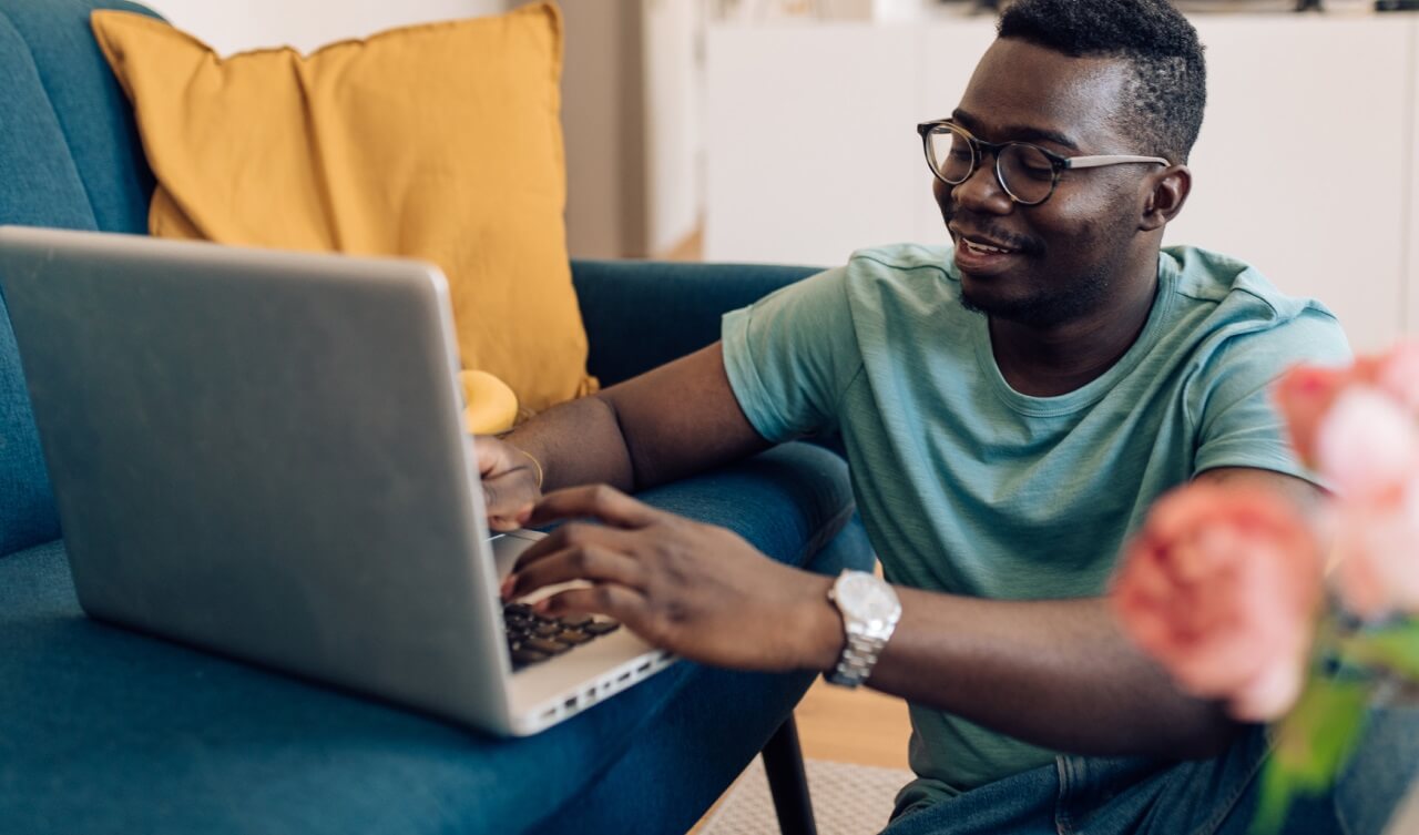 young man smiling using laptop